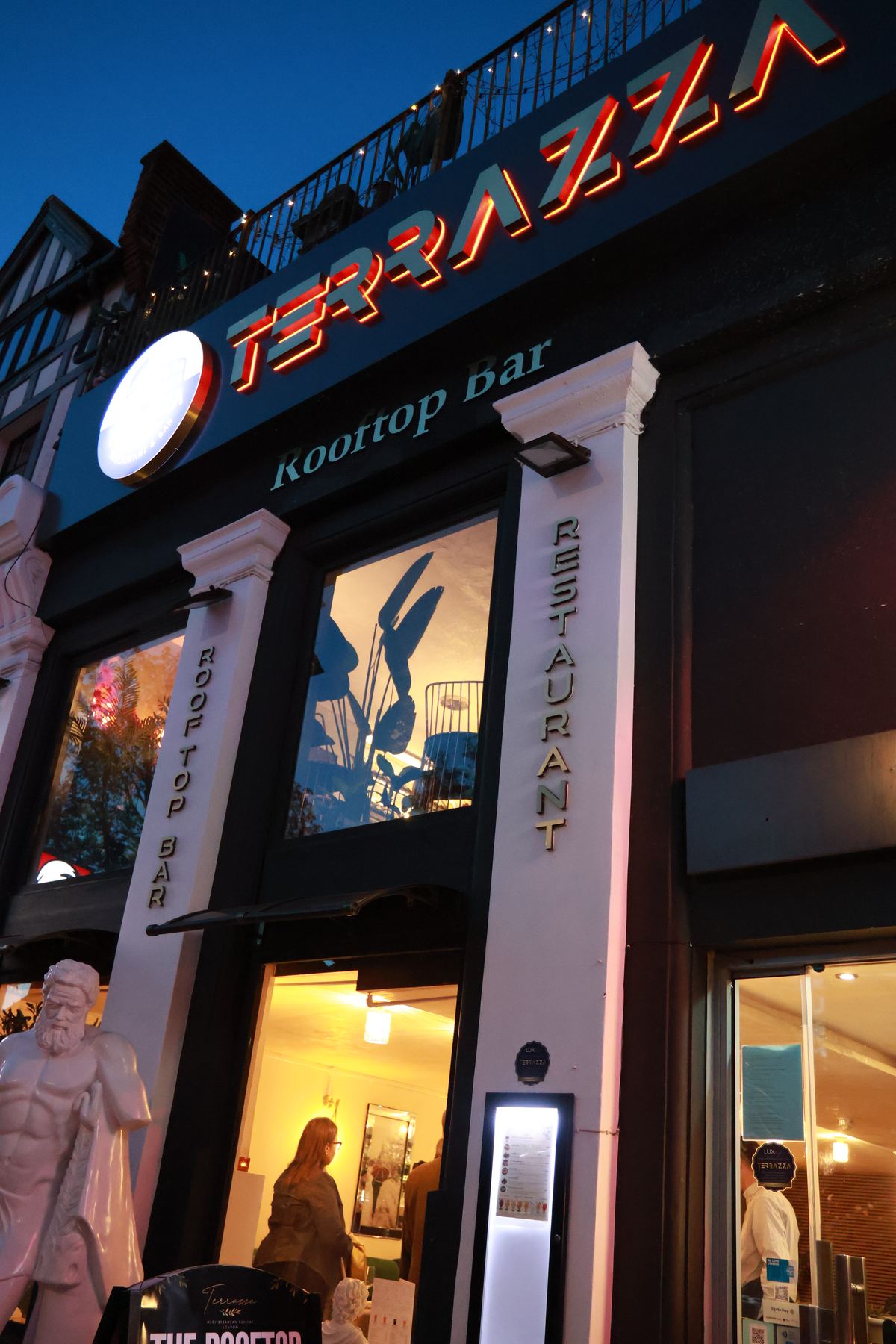 Terrazza's lit facade on Haverstock Hill at dusk