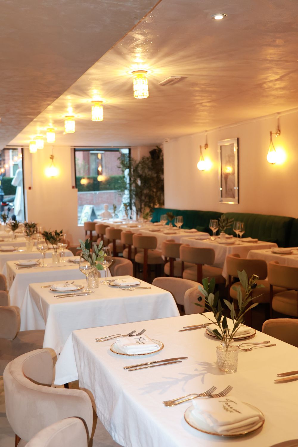 The ground-floor dining room laid with long white-clothed tables